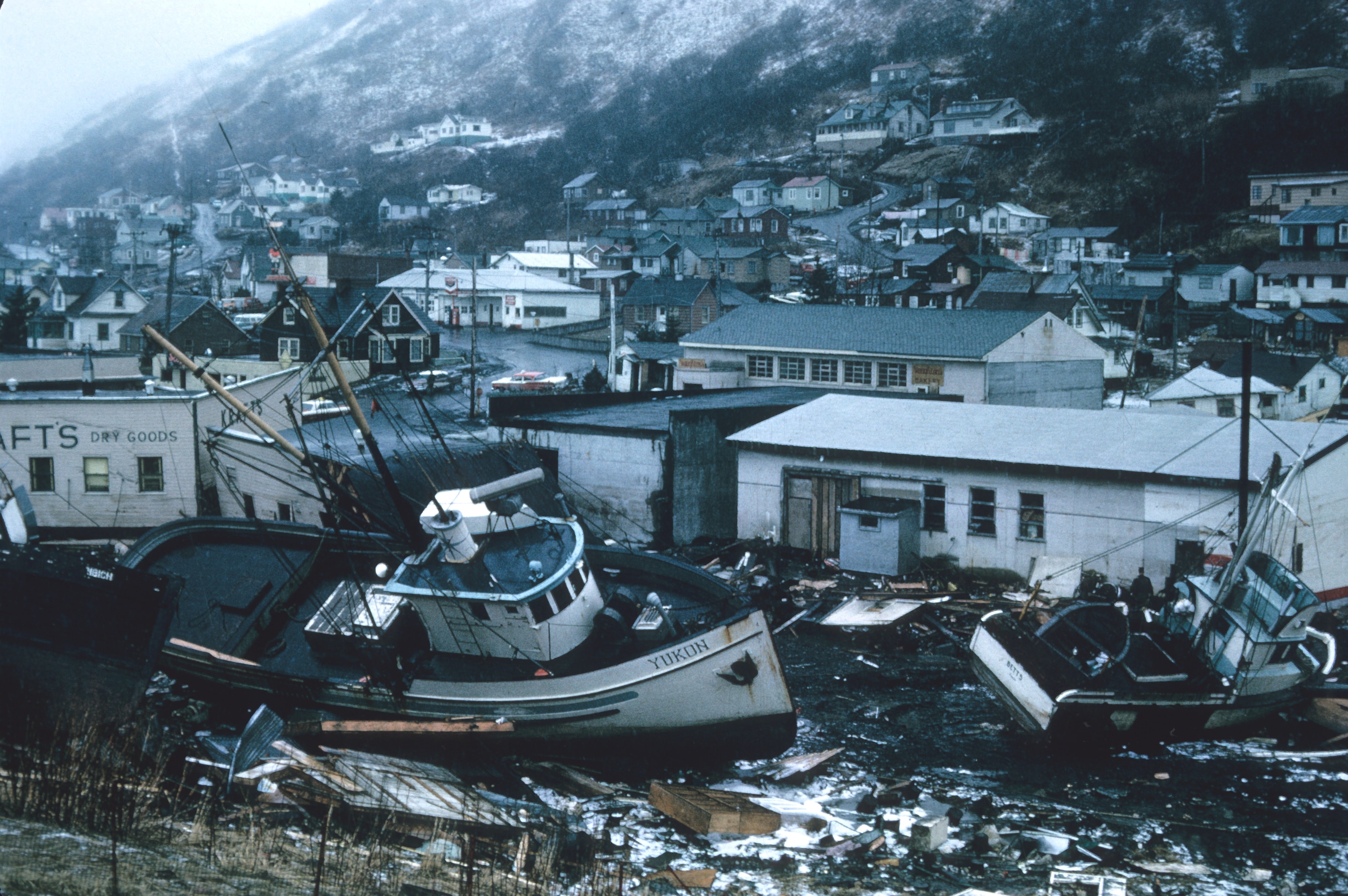 a boat sits amid ruins of buildings damaged by earthquake and tsunami