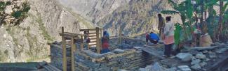 women build a stone house in a mountainous area