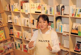 Person in apron in front of bookshelves
