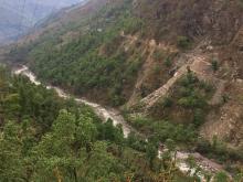 A gravel road traverses a steep mountainside