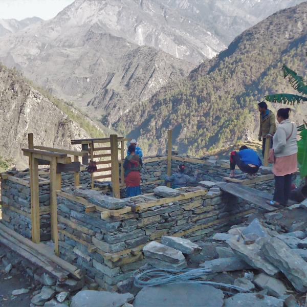 women build a stone house in a mountainous area